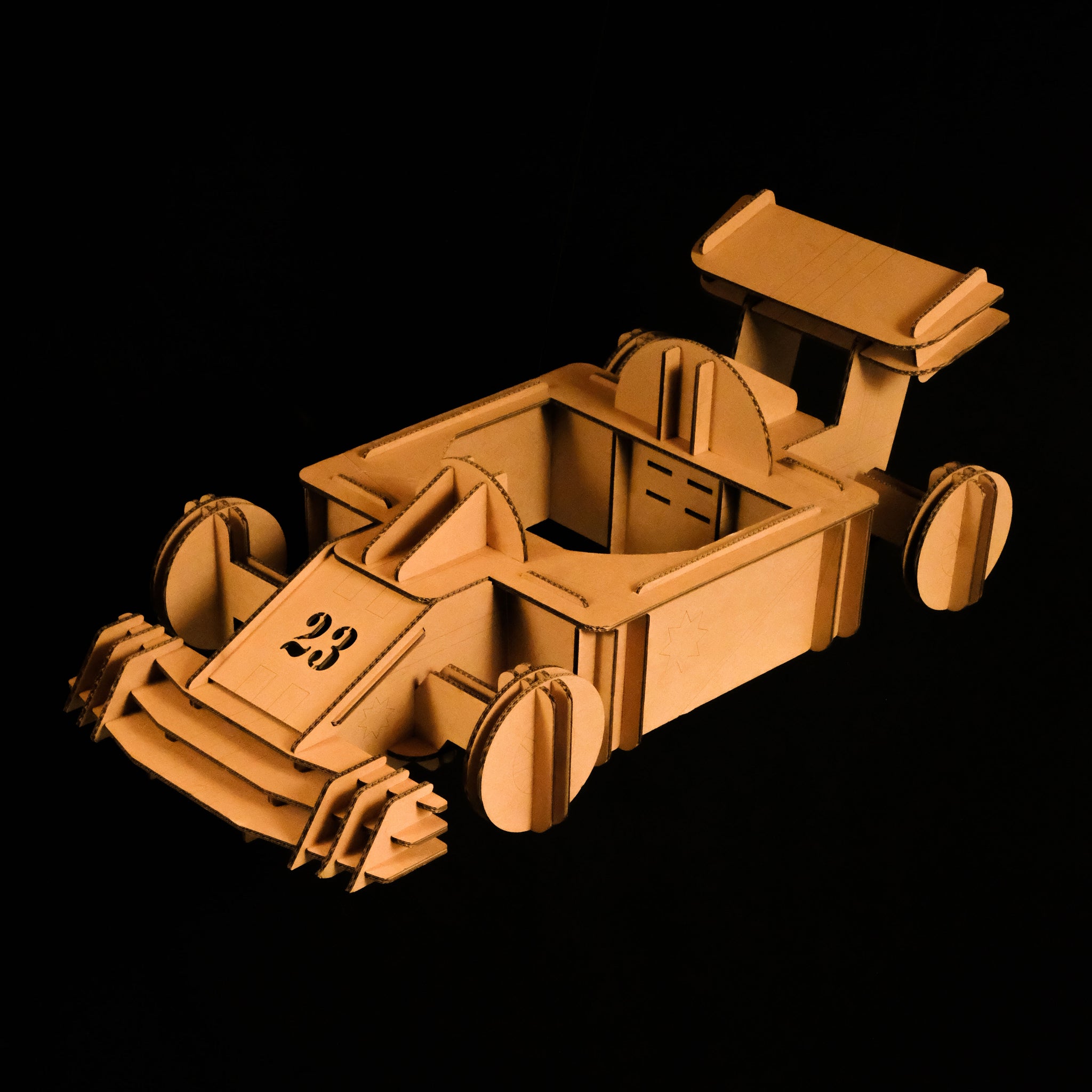 Un déguisement de Formule 1 en carton recyclé pour enfant à construire, peindre et colorier soi même sur fond noir Tonton Carton