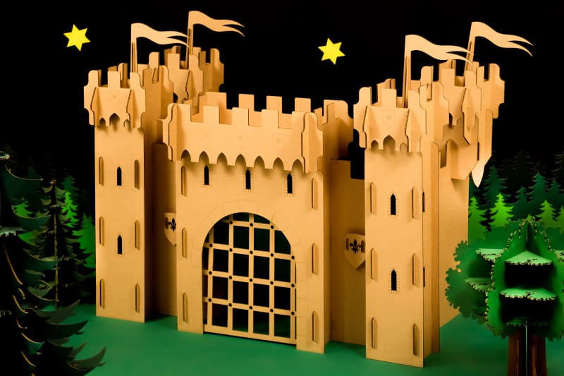 Un château Fort en carton recyclé entouré d'arbres et de sapins en carton recyclé à assembler, décorer, colorier soi même